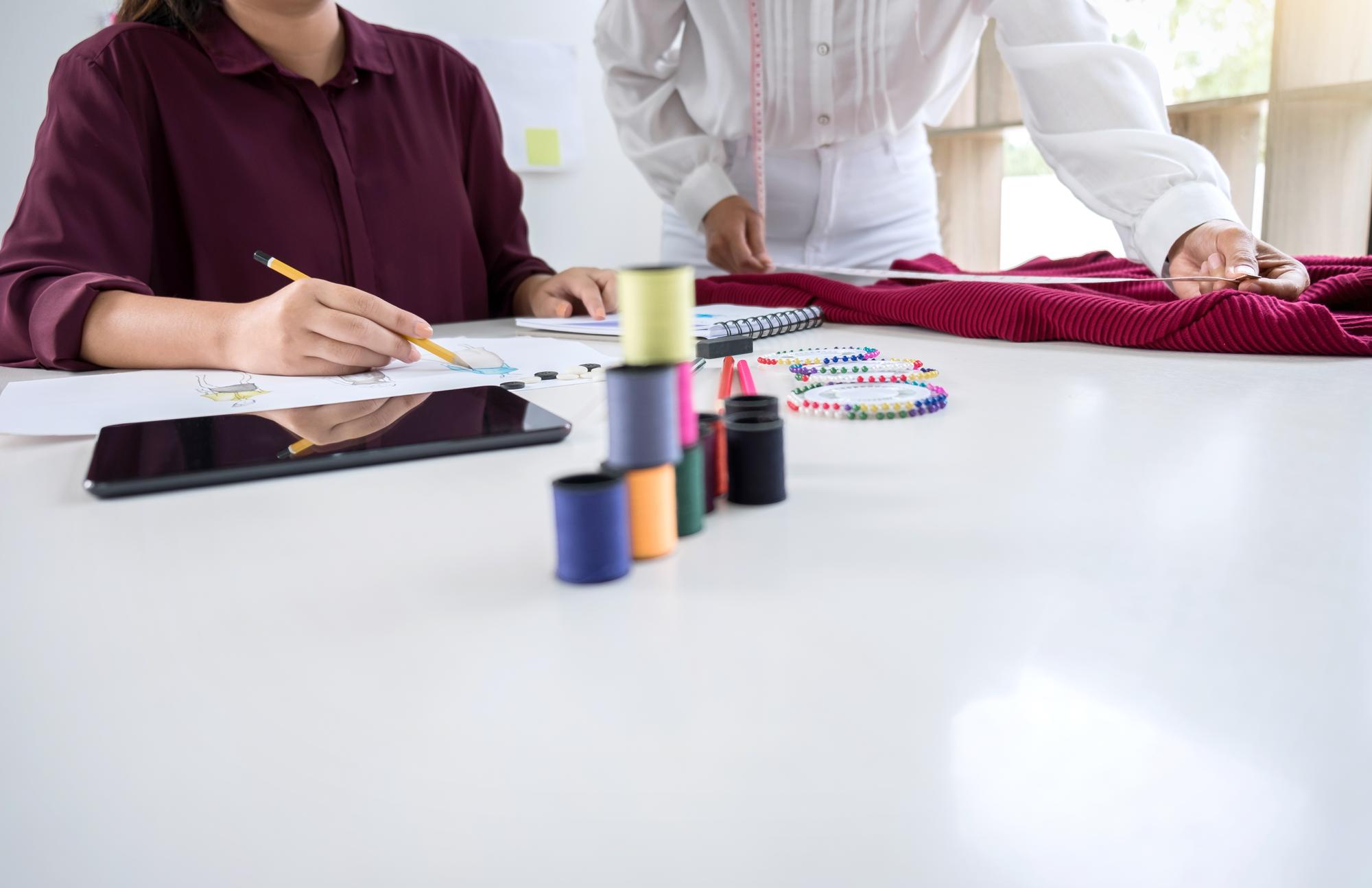 Tutor al tavolo di lavoro con campioni ricamati